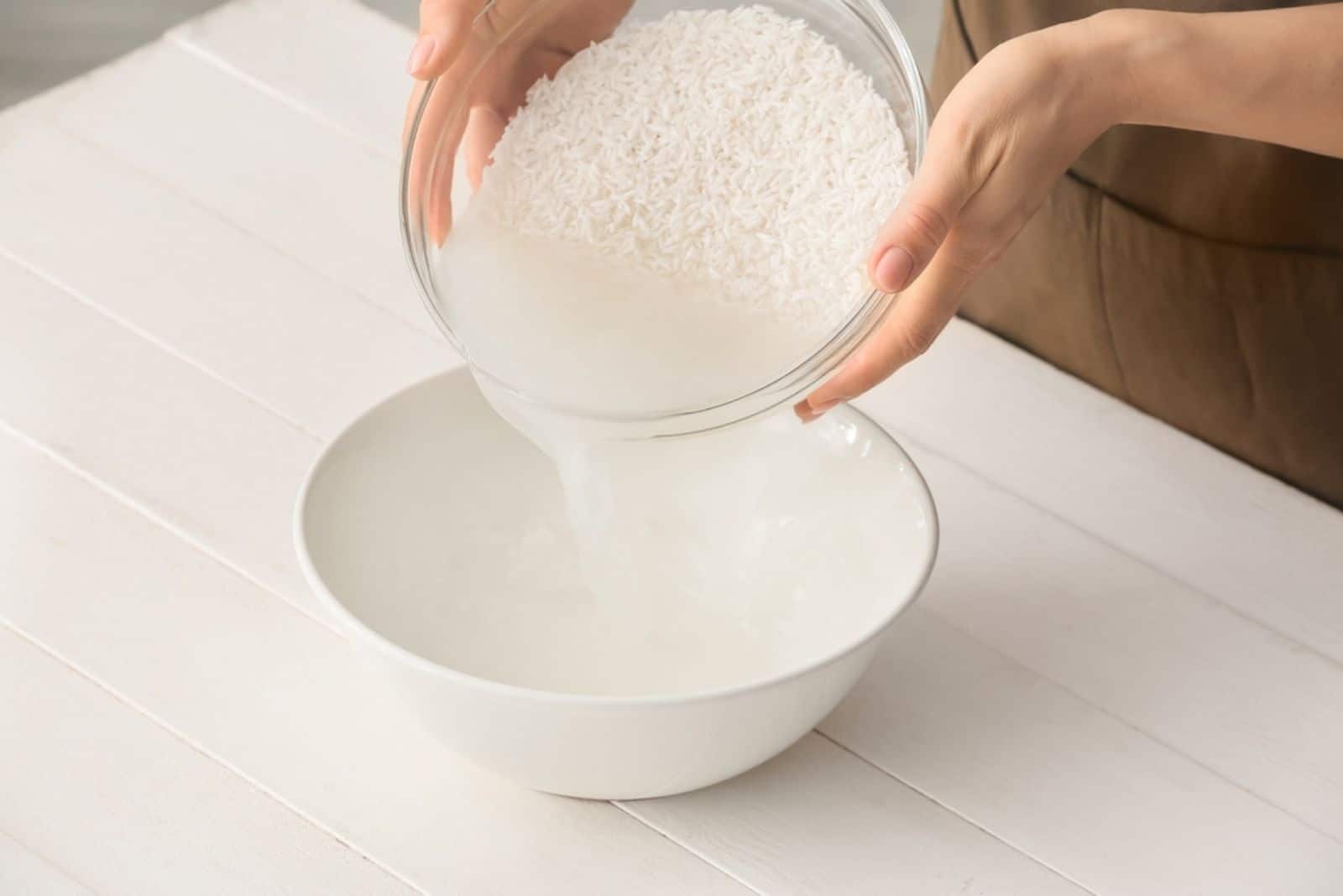 Mujer preparando agua de arroz en la mesa