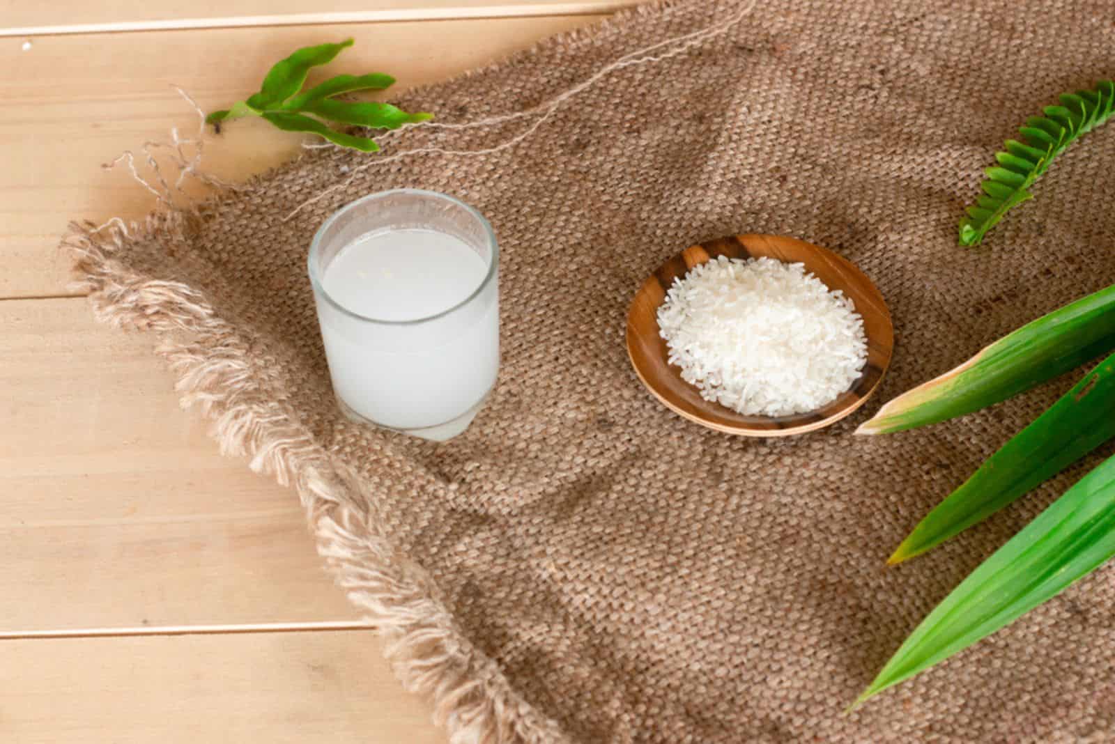 vaso de agua de arroz con hojas sobre la mesa